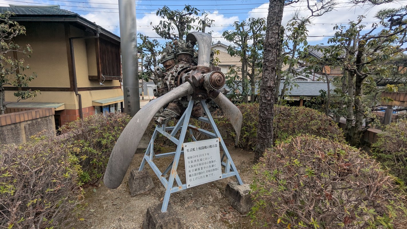 圖片展示了位於日本八幡市的飛行神社的入口，背景是藍天。